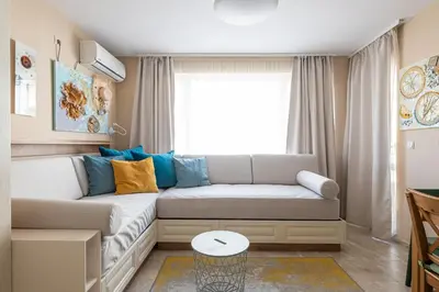 a living room with a couch and a window at Aquamarine in Pomorie