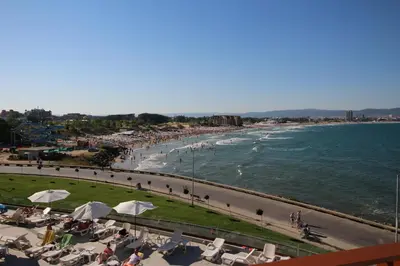 a beach with people sitting on chairs and the ocean at PARADISO 'В' 310 Private Room Nessebar in Nesebar