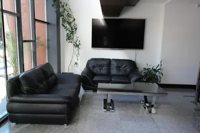 a living room with two leather couches and a tv at PARADISO 'В' 310 Private Room Nessebar in Nesebar