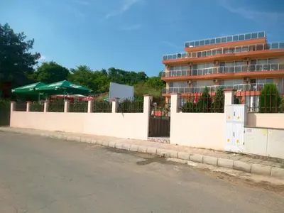 a white fence with a building in the background at Safo Apartments and Rooms in Sozopol