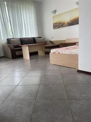 a room with two beds and a couch and a table at Safo Apartments and Rooms in Sozopol