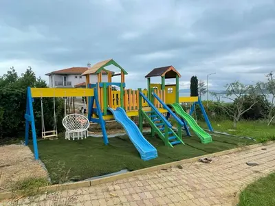 a playground with a slide in a yard at Safo Apartments and Rooms in Sozopol