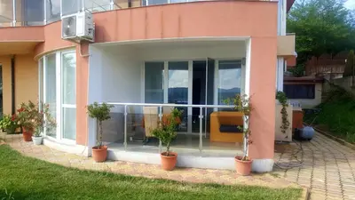 a house with potted plants in front of it at Safo Apartments and Rooms in Sozopol