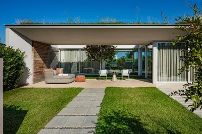 a patio with a couch and chairs in a house at Vaya Beach Resort in Emona