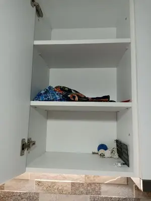a white cupboard with shelves in a room at Apartment SEA HOLIDAYS in Burgas City