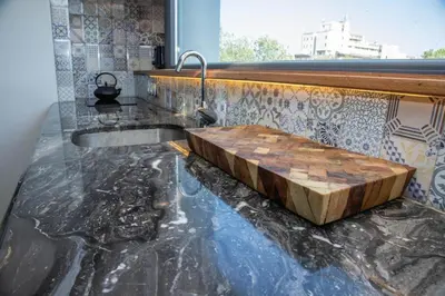a bathroom with a stone counter top with a wooden tub at ART LUXURY Apartment in Burgas City