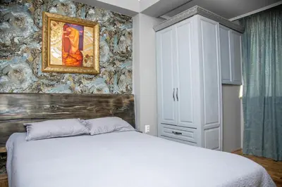 a bedroom with a bed and a painting on the wall at ART LUXURY Apartment in Burgas City