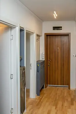 a hallway with a wooden door and a wooden floor at ART LUXURY Apartment in Burgas City