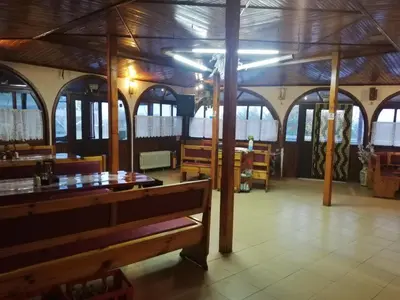 a restaurant with a wooden ceiling and tables and benches at Bar & Guests room ELA in Dolen Bliznak