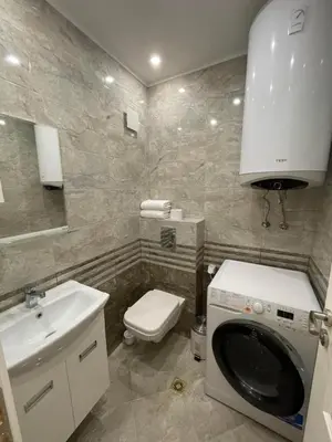 a bathroom with a washing machine and a sink at CENTRAL Lux Apartment in Varna City