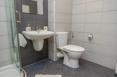 a bathroom with a toilet and a sink at Lovely 3BD flat with PARKING and SEA VIEW by Flаt Manаger in Chernomorets