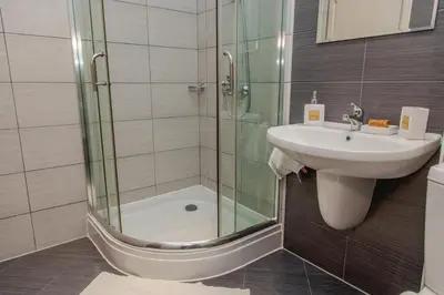 a bathroom with a sink and a glass shower at Lovely 3BD flat with PARKING and SEA VIEW by Flаt Manаger in Chernomorets
