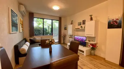 a living room with a table and a couch and a television at Sozopol Dreams apartman 35 in Sozopol