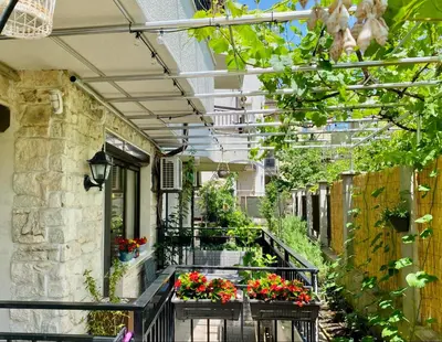 an outdoor walkway with flowers and plants in pots at Sozopol Dreams apartman 35 in Sozopol