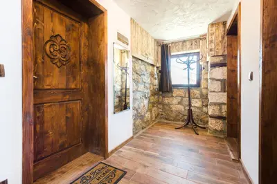 a hallway with a wooden door and a window at Guest House Hristova Kashta - Христова Къща in Cherni Vrŭkh
