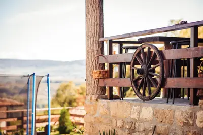 a wooden cannon sitting on the side of a building at Guest House Hristova Kashta - Христова Къща in Cherni Vrŭkh