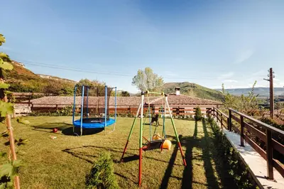 a playground with two swings in a yard at Guest House Hristova Kashta - Христова Къща in Cherni Vrŭkh