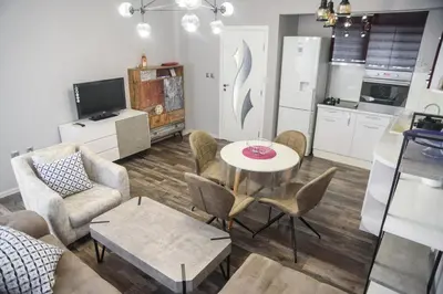 a living room with a table and chairs and a kitchen at Apartment MARTINI in Burgas City