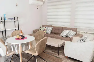 a living room with a couch and a table and chairs at Apartment MARTINI in Burgas City