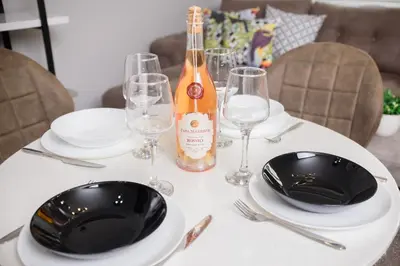 a table with two plates and a bottle of wine at Apartment MARTINI in Burgas City