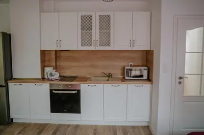 a kitchen with white cabinets and a sink and a microwave at Bella's Sea apartment-Beach, Sea garden ,Old Town, Free Parking, Free EVcharging Station in Varna City