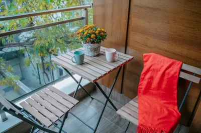 a table and a chair on a balcony with flowers at Bella's Sea apartment-Beach, Sea garden ,Old Town, Free Parking, Free EVcharging Station in Varna City