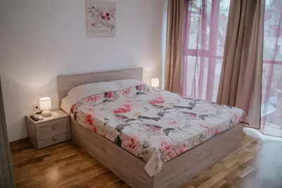 a bedroom with a bed with a floral bedspread and a window at Bella's Sea apartment-Beach, Sea garden ,Old Town, Free Parking, Free EVcharging Station in Varna City