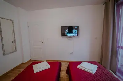a room with two beds and a tv on the wall at Bella's Sea apartment-Beach, Sea garden ,Old Town, Free Parking, Free EVcharging Station in Varna City