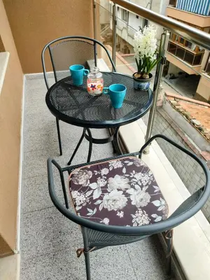 a wrought iron table and chair with cups on a balcony at Aпартамент 5 in Varna City