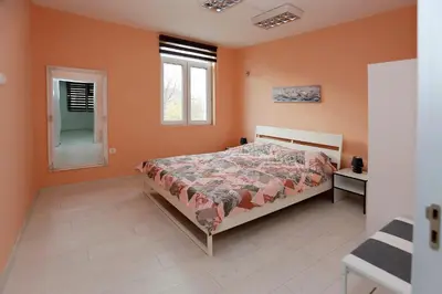 a bedroom with a bed with orange walls and a window at Lux Apartment 