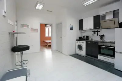 a white kitchen with a washing machine and a washer at Lux Apartment 