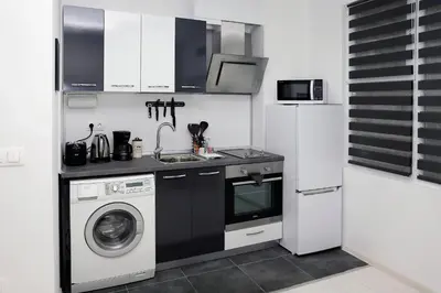 a kitchen with a washing machine and a washer at Lux Apartment 
