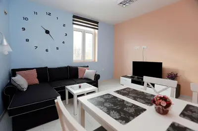 a living room with a couch and a clock on the wall at Lux Apartment 