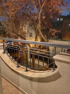a railing on a balcony with a tree and a building at Stylish URBAN Apart New 2021 Close to the Beach in Varna City