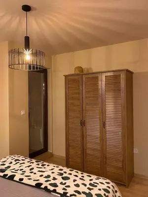 a bedroom with a bed and a wooden cabinet at Stylish URBAN Apart New 2021 Close to the Beach in Varna City