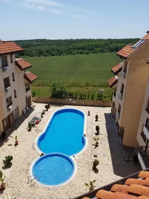 an overhead view of a swimming pool between two buildings at CarolMike Oasis Beach Apartment Kamchia Reserve in Kamchia