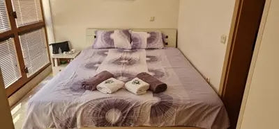a bed with three pillows on it in a bedroom at CarolMike Oasis Beach Apartment Kamchia Reserve in Kamchia