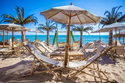 a group of chairs and umbrellas on a beach at Villa Orange in Sozopol