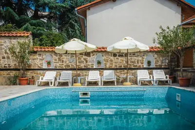 a swimming pool with two umbrellas and chairs at VILLA SOL in Sunny Beach