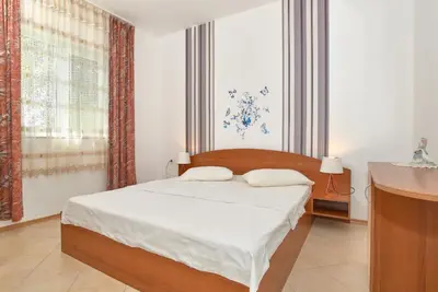 a bedroom with a bed and a large window at BulgariaVilla - Villa Amber in Bryastovets