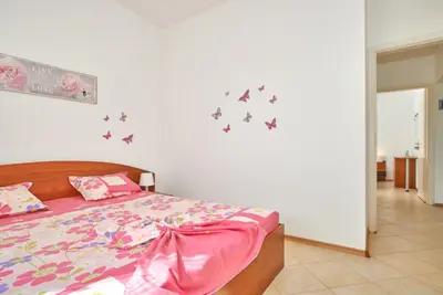 a bedroom with a bed with butterflies on the wall at BulgariaVilla - Villa Amber in Bryastovets