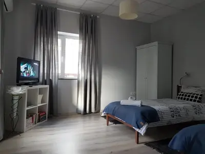 a bedroom with a bed and a television and a window at Flat in Varna, central location, close to beach in Varna City