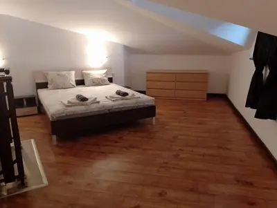 a bedroom with a bed and a wooden floor at Pearl Apartments Sozopol in Sozopol