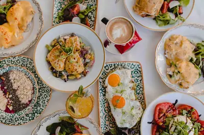 a table with plates of food and a cup of coffee at Royal Hotel in Varna City