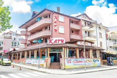 a pink building with a restaurant in front of it at Къща за гости КАТИ in Kiten