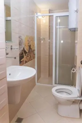 a bathroom with a toilet and a shower and a sink at Къща за гости КАТИ in Kiten