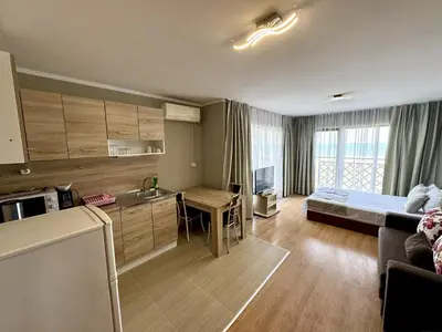 a room with a kitchen and a living room at Teos Apartments Primorsko in Primorsko