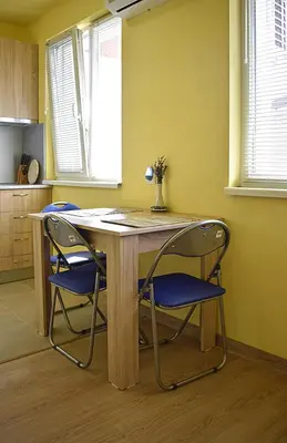 a wooden table with two blue chairs in a kitchen at Starlight Studios in Burgas City