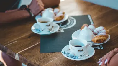 a table with two cups of coffee and pastries at Boryana Hotel in Burgas City