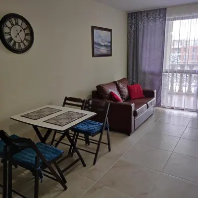 a living room with a table and a couch at Kalia Apartment Sunny Beach 2-Zimmer+Balkon TOP in Sunny Beach